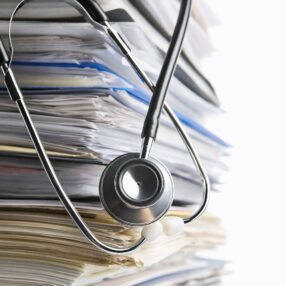 scanning a stack of medical records with stethoscope